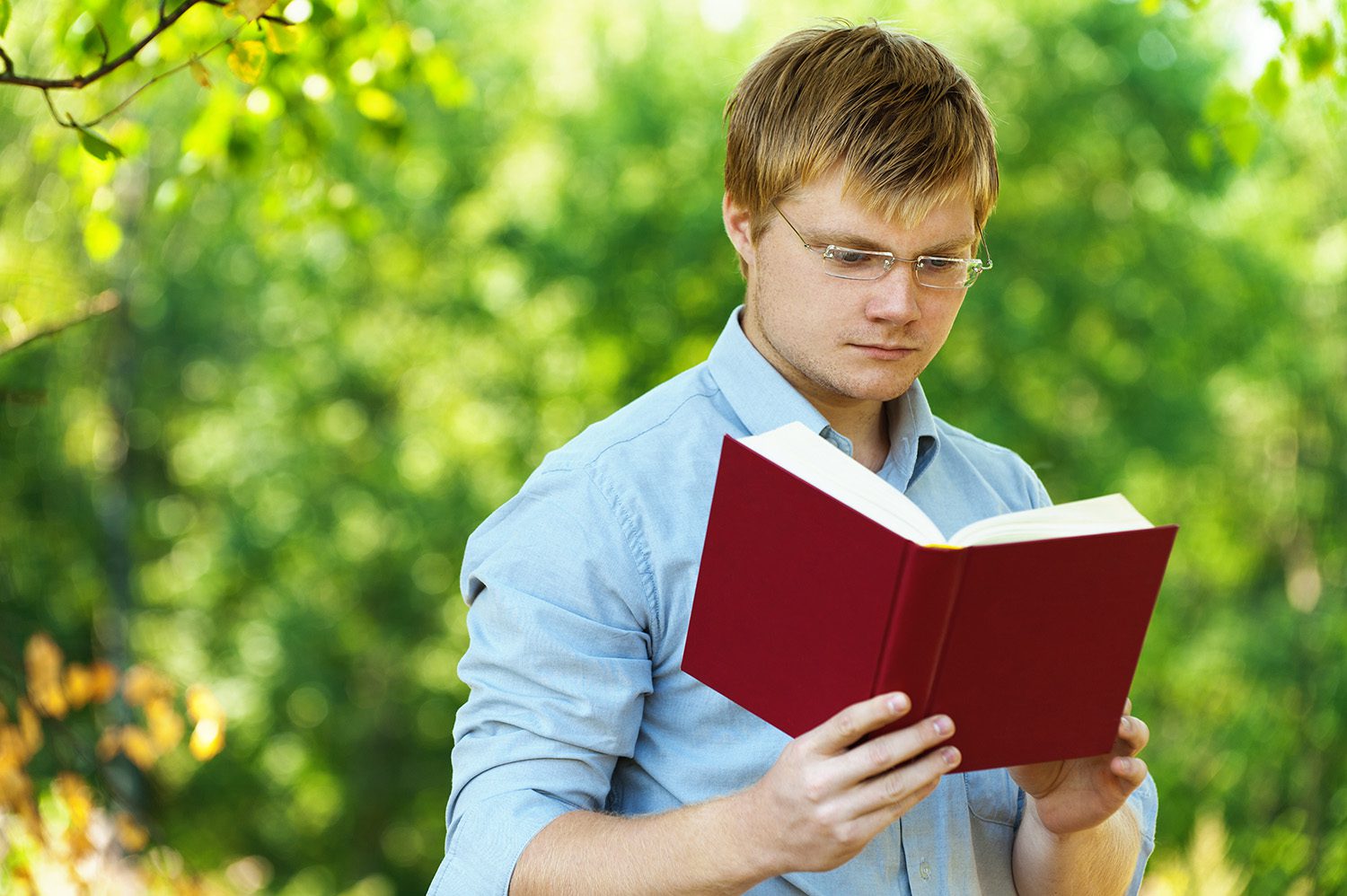 Читая учебники ребята. Парень с книгой. Молодой человек с книжкой. Человек студент. Юноша с книжкой.